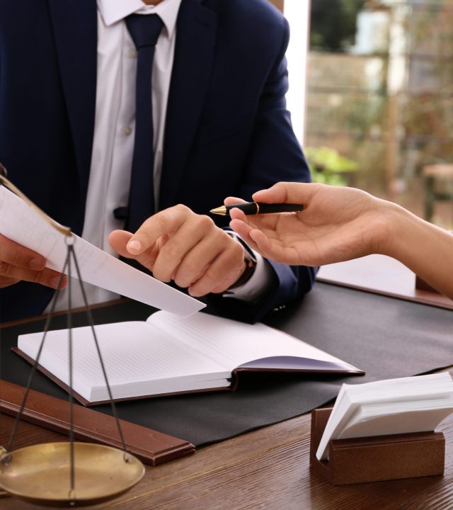 Lawyer,Working,With,Client,At,Table,In,Office,,Focus,On